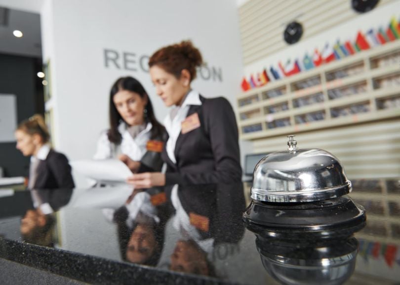Hotel workers at a reception desk.