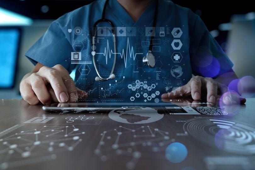 stock image of a doctor in scrubs working with future tech holograms and artificial reality