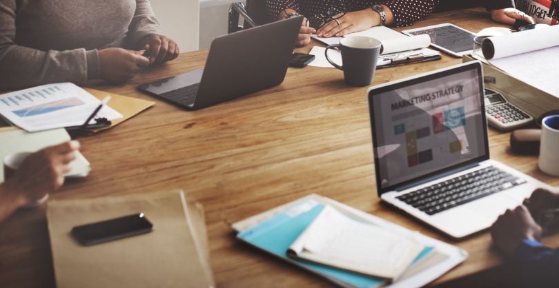 A conference table during a meeting in which marketing and advertising is being discussed.