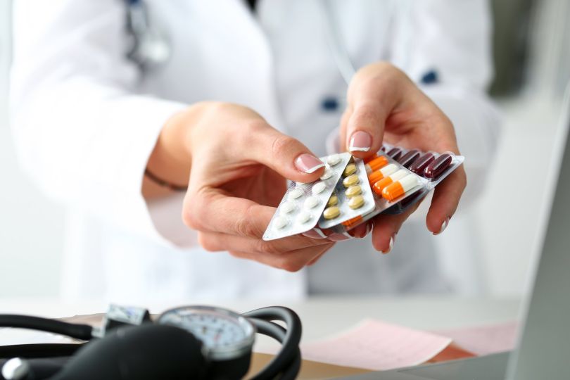A pharmacist fans out packets of prescription pills.