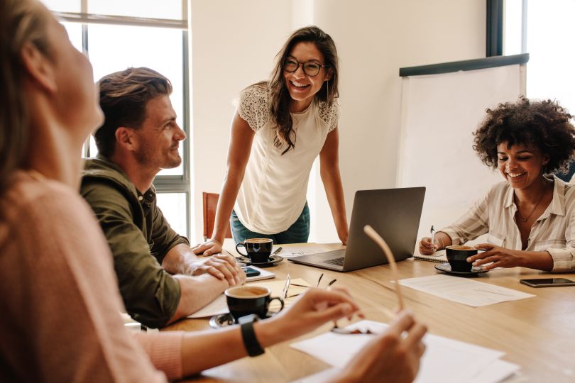 A team meeting in a conference room sharing a laugh