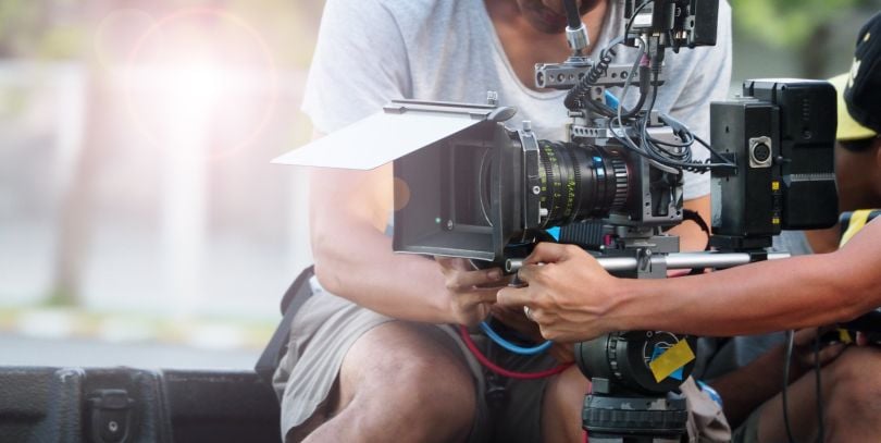 stock photo of person with film camera shooting 
