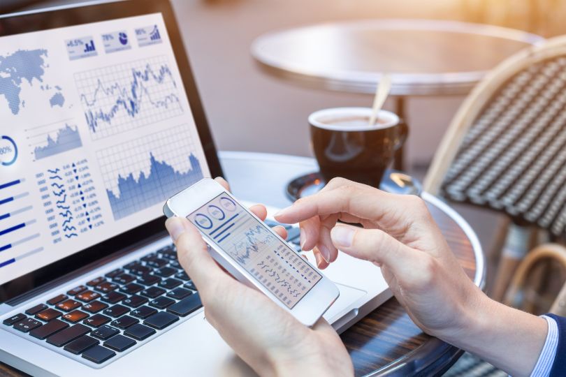 A user interacts with financial software on a mobile phone. 