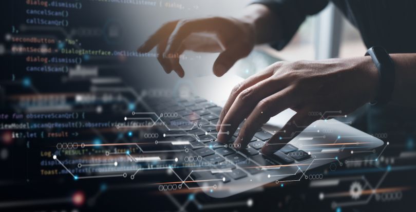A person codes on a keyboard.