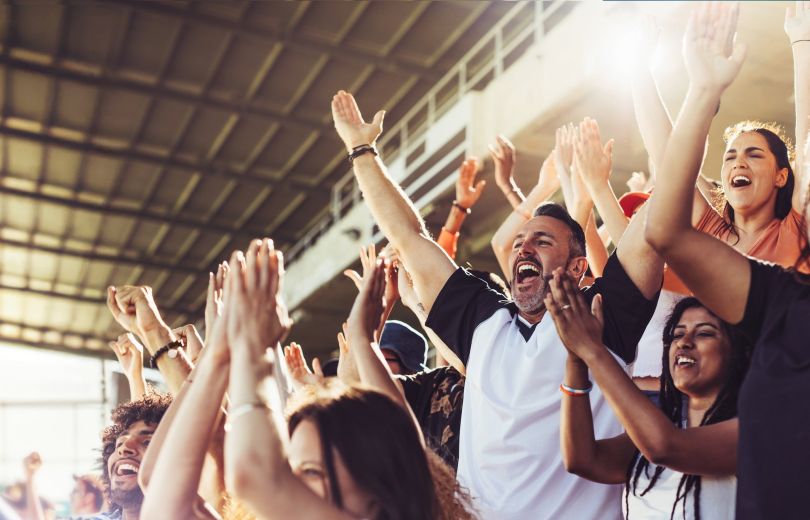 A crowd of cheering sports fans is pictured.