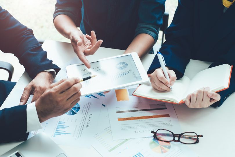 A photo of business people having a meeting is shown.
