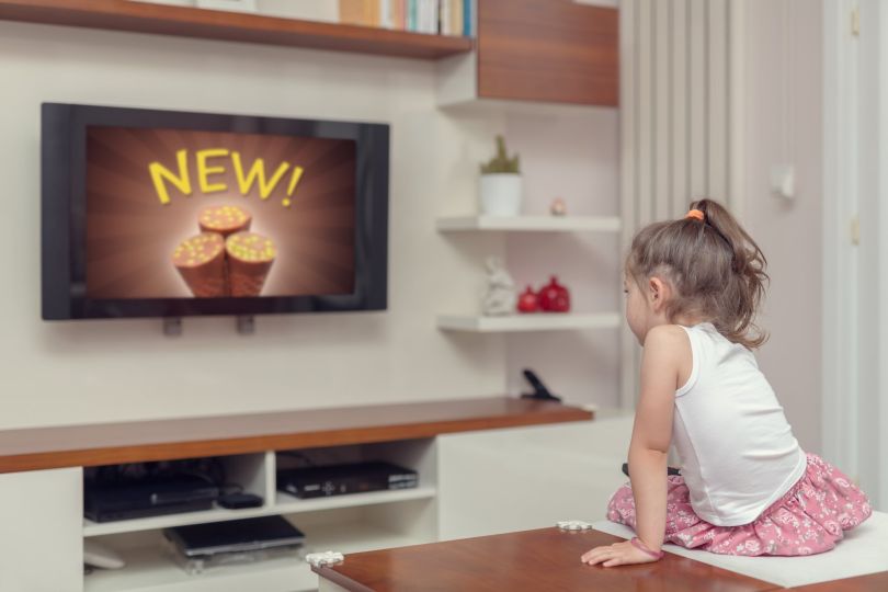 A young person watches an advertisement on TV.