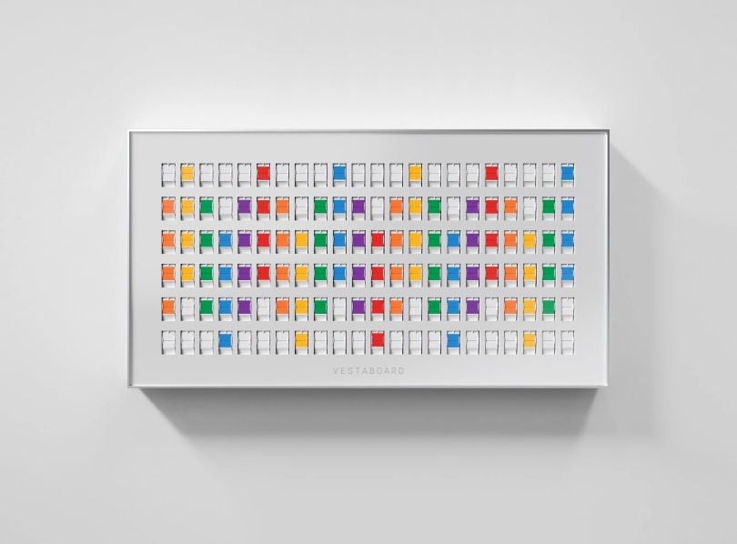 A white Vestaboard with colorful display