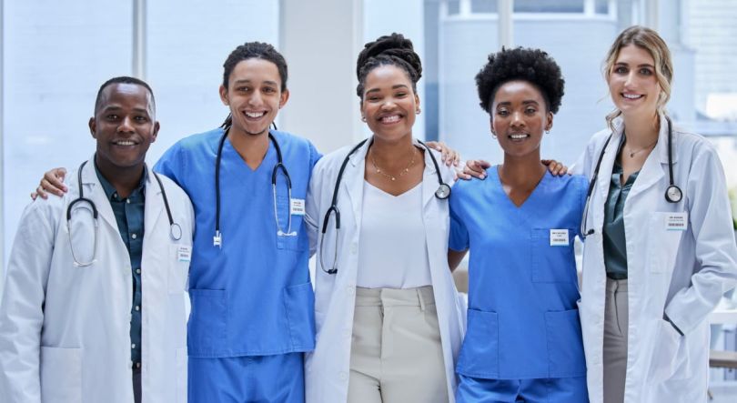 A group of healthcare professionals, each in their medical attire, standing together.