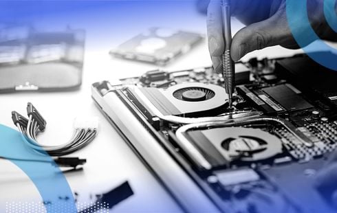 A close-up on the hand of someone repairing a dismantled laptop.