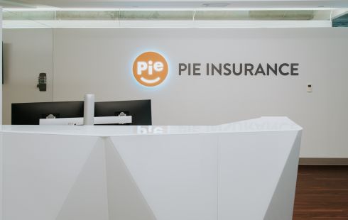 A lit Pie Insurance logo shines in the company’s lobby.